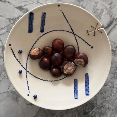 Blue and white bowl. Thrown stoneware with beads and leather.